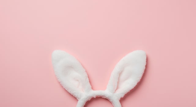 Easter Bunny Ears on Soft pink Pastel Background. A top-down view of cute rabbit ears in a simple yet elegant Easter-themed composition, ideal for digital designs and seasonal decorations photo