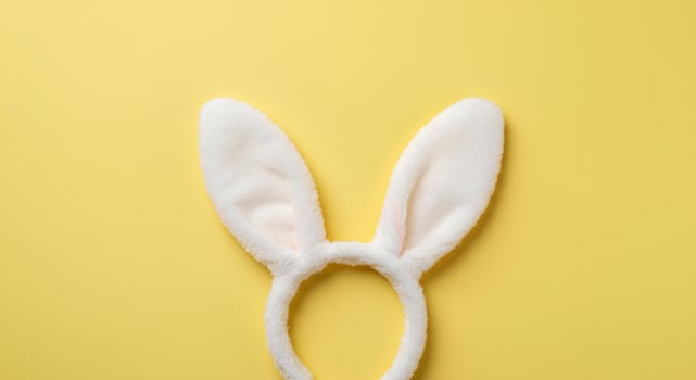 Festive Bunny Ears for Easter Holiday on Pastel Yellow. A cheerful and clean Easter-themed flat lay featuring rabbit ears, symbolizing rebirth, renewal, and the spirit of the spring season photo