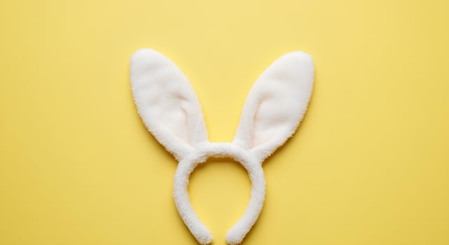 Easter Bunny Ears on a Soft Yellow Background. A playful and festive composition featuring rabbit ears on a pastel baby yellow background, perfect for Easter holiday celebrations photo
