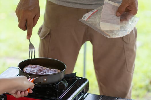 A man and a child cooking food on a stove photo
