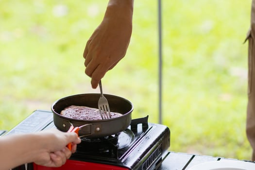 A person cooking food on a stove top photo