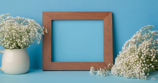 Wooden frame with white flowers on blue background photo