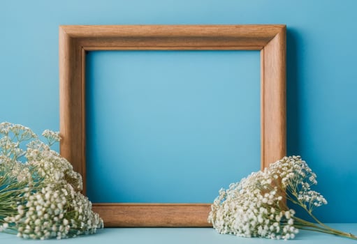 Wooden frame with baby's breath on blue background photo