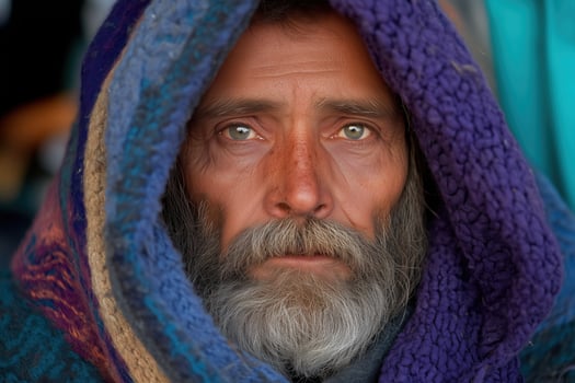 portrait, look of an elderly houseless man wrapped in warm clothes photo