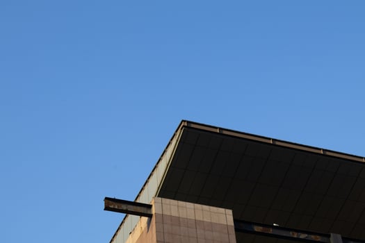 A close-up view of the rooftop edge of a high-rise building on a clear day. photo