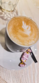 Coffee in white cup with small candy photo
