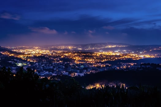 City lights illuminating the night sky and surrounding hills photo