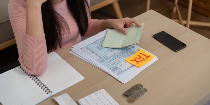 Woman reviewing tax documents and preparing for financial planning photo