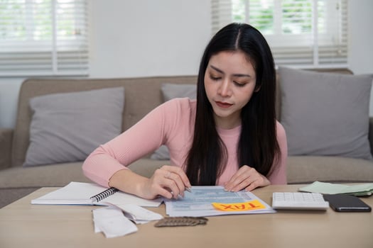 Woman focused on tax preparation with financial documents and calculator photo