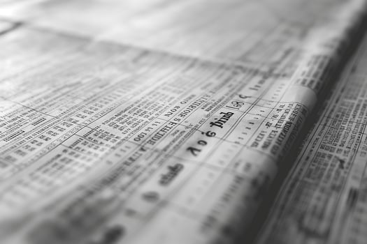 Close-up view of vintage newspaper with faded print and columns of information. photo
