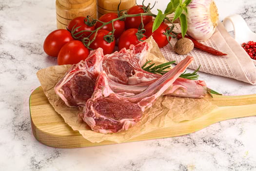A wooden cutting board with meat and vegetables photo