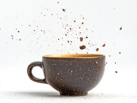 Beautiful ceramic cup of tea with dynamic splatter on white background photo