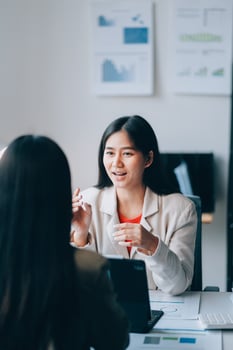Two women talking in an office setting photo