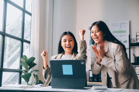 Two asian women celebrating on a laptop photo