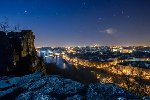 Starry night sky over illuminated prague with vltava river and bridges, vysehrad photo