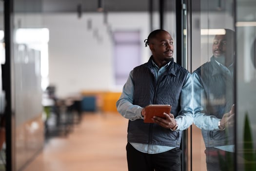 A confident, mature businessman in his 40s-50s using a tablet in a modern office. He is engaged in digital finance management, leveraging technology and artificial intelligence for investment photo