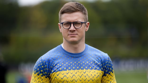 A man in glasses wearing a blue and yellow shirt photo