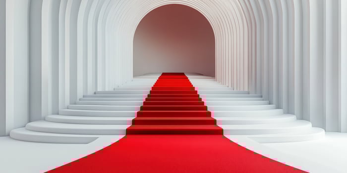 Elegant red carpet leads up a set of white stairs in a modern architectural space photo