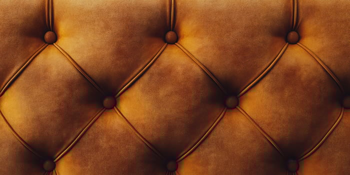 Detailed close-up of tufted leather upholstery showcasing rich textures and warm colors in a modern interior setting photo