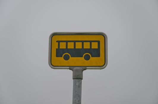 Bus Stop Sign Against Gray Sky photo