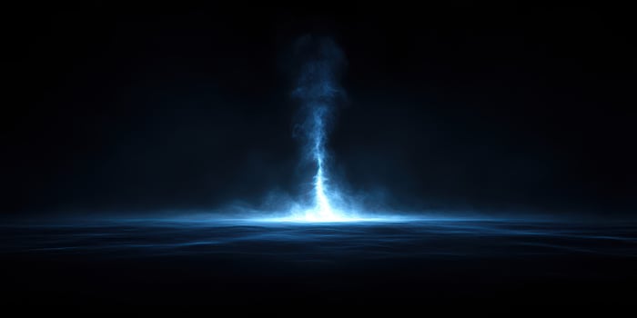 Dramatic display of blue mist ascending from a dark surface in a mysterious atmosphere during nighttime photo
