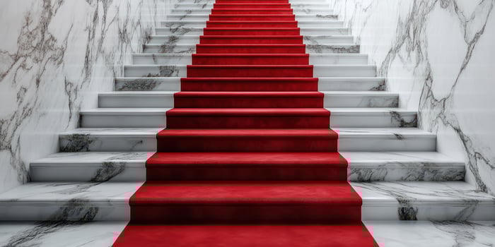 Elegant red carpeted stairs leading up through a marble hallway in a luxurious setting photo