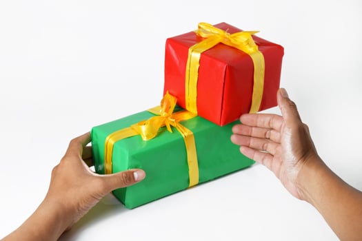 Someone's hand is holding and showing a red gift box photo