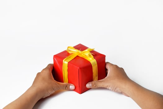 A Man Holding a Stack of Christmas-Themed Gifts photo