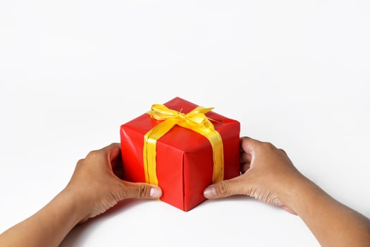 A Man Holding a Stack of Red and Green Presents photo