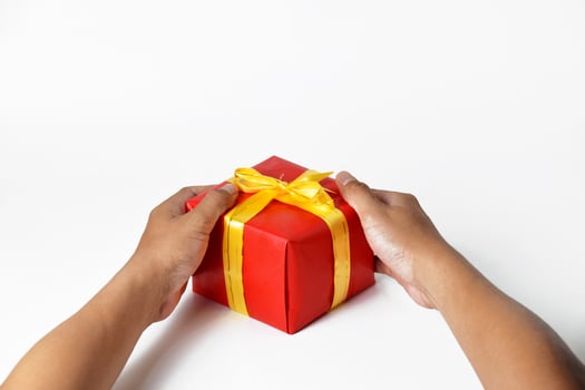 A Mans Hands Holding Multiple Green and Red Gifts photo