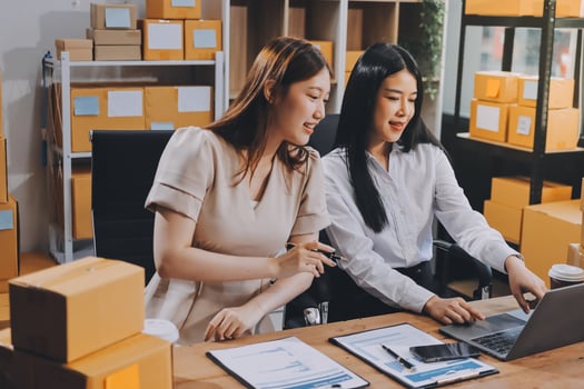 Two women working on a laptop in an office photo