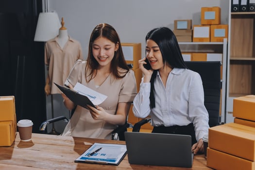Two women in an office with boxes and papers photo