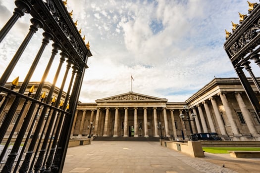 The British Museum grand neoclassical facade in London features towering columns and symmetrical design, standing proudly under an expansive sky. photo
