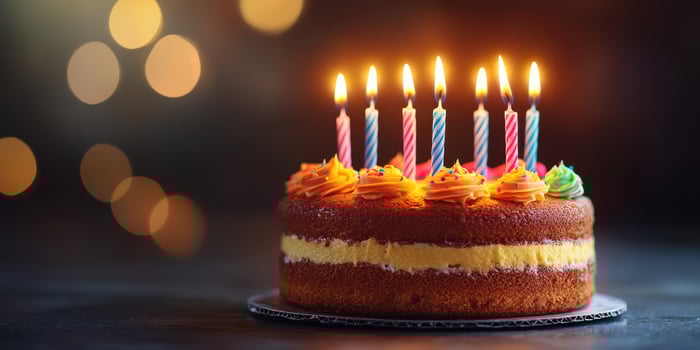 Colorful birthday cake with candles glowing in a celebratory atmosphere at a festive gathering photo