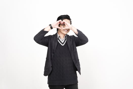 A man in a sweater and jacket making a heart shape with his hands photo