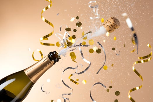 Champagne bottle pops golden confetti, capturing excitement and festivity photo