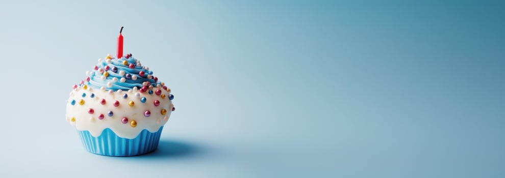 Colorful sprinkled cupcake bearing lit birthday candle resting on vivid blue surface, celebrating sweet moment photo