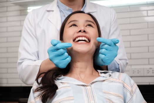 Beautiful Asian woman face, white teeth, and cheerful face in Asian dentist's hand, dental treatment with tooth whitening and cleaning in doctor hospital clinic, oral hygiene healthcare. photo