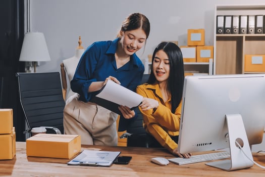 Two women working on a computer in an office photo