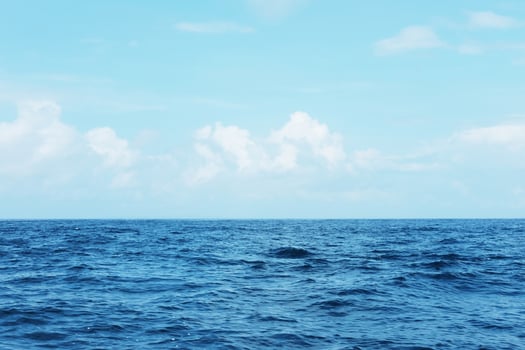 Landscape of horizontal calm blue sea with wave and cloud and blue sky in bright day. Travel destination summer of ocean in Asian. Copy space photo
