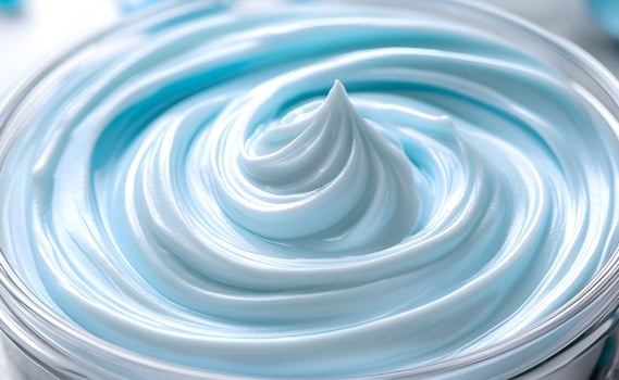 Creamy blue moisturizer swirled perfectly in a container showcasing its smooth texture for skincare enthusiasts and beauty aficionados photo