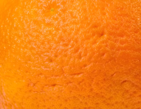 Close-Up of Orange Skin Showing Natural Texture and Vibrant Hue photo