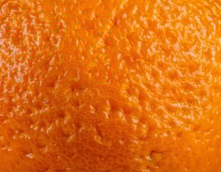 Detailed View of Citrus Peel with Tiny Pores and Rich Orange Tone photo