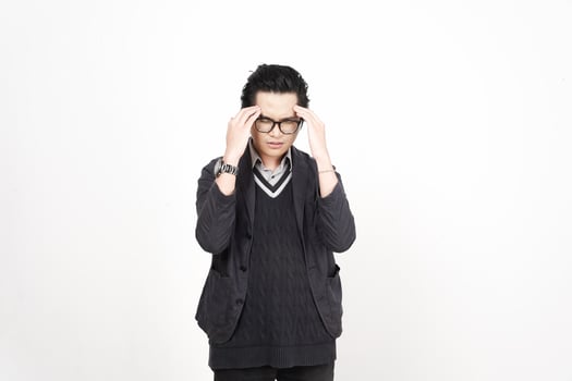 A man with glasses and a sweater is holding his head photo