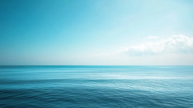 A serene view of a turquoise sea under a pastel blue sky with a few white clouds on the horizon, evoking tranquility and peace. photo