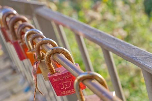 Colorful mostly red Love Locks on a Railing photo