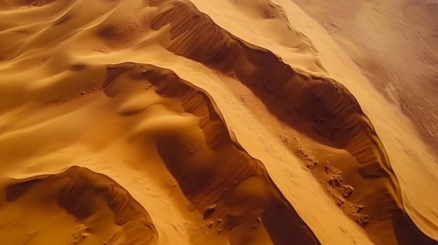 Aerial view of a vast desert landscape showcasing the undulating patterns of sand dunes under the warm light, perfect for backgrounds. photo