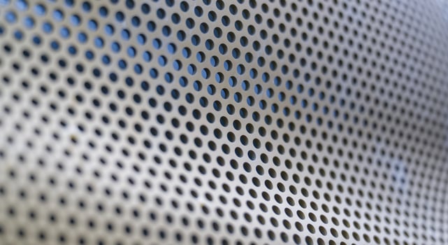 Close-Up of Perforated Metallic Surface photo