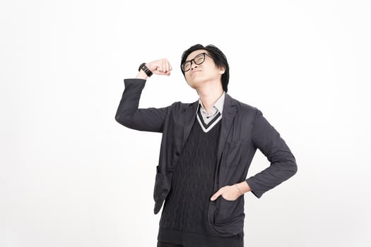 A man in glasses and a sweater is standing with his arms up photo