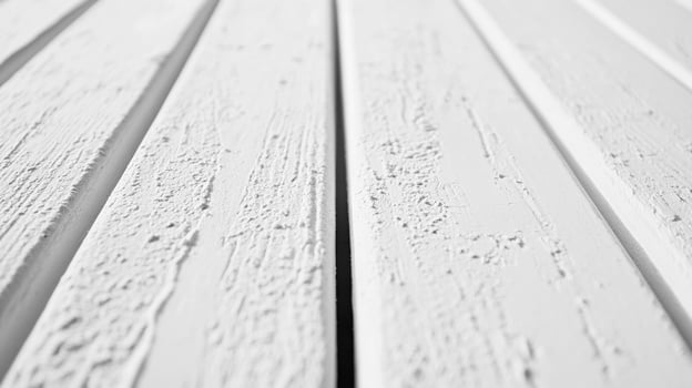 White painted wooden planks are viewed in this up close, monochromatic image, showcasing the rough, textured surfaces and clean, minimal design. photo